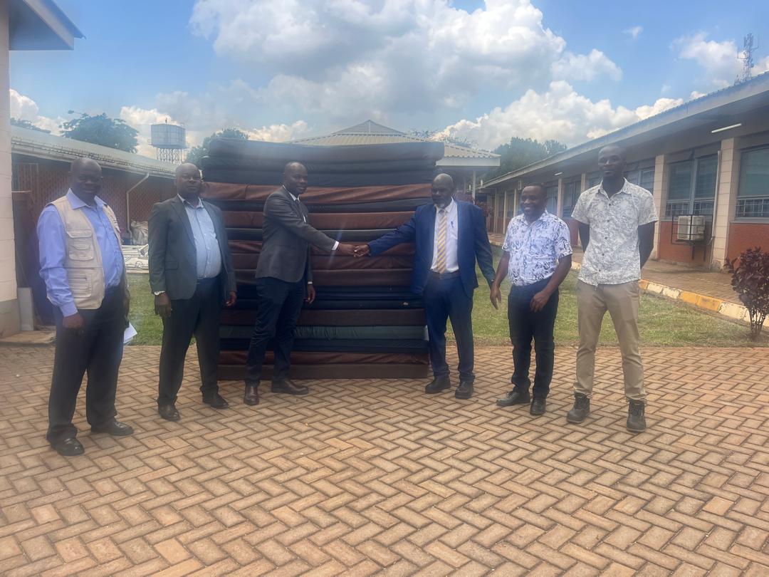 :(center), the Kayunga RRH Board Chairperson Dr. Mpooya Simon handing over 20 mattresses to Hajji Isa Mbooge(yellow neck tie) the Buvuma CAO int the presence of Hajji Salim Kivejinja-Hospital Administrator (2nd left) and Buvuma HCIV Incharge (2nd right)